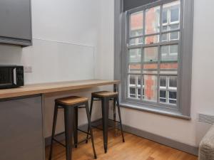 - une cuisine avec deux tabourets de bar devant une fenêtre dans l'établissement Apartment 9, à York 9 autres photos