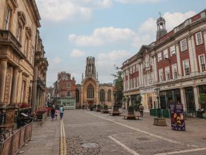 une rue urbaine avec des bâtiments et des gens qui marchent dans la rue dans l'établissement Apartment 9, à York
