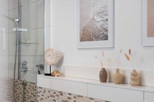 a bathroom with a glass shower stall with vases on a shelf at Ferienwohnung Mayer in Albstadt +22 photos