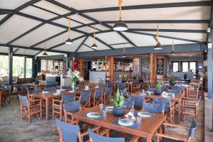a dining room with wooden tables and chairs at Sunwaves Beach Hotel in Vasiliki