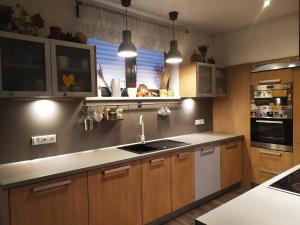 a kitchen with wooden cabinets and a sink and a window at Family house in Pardubice