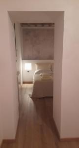 a white bedroom with a bed and a lamp at Frattina1860 in Montisi +31 photos