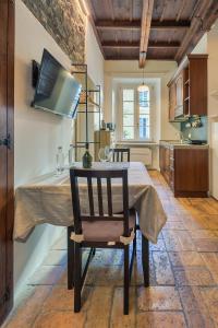 a kitchen with a table with a chair and a television at Angolo Medioevale - Como Centro in Como +13 photos