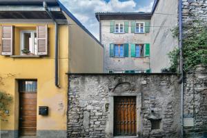 an old stone building with colorful windows and a door at Angolo Medioevale - Como Centro in Como