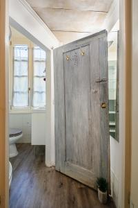 an old wooden door in a bathroom with a toilet at Angolo Medioevale - Como Centro in Como