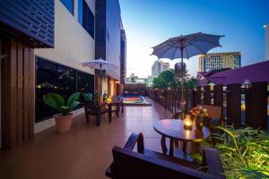 a patio with tables and umbrellas on a building at CM Night Bazaar Boutique Hotel - โรงแรม ซี เอ็ม ไนท์บาซาร์ บูทีค in Chiang Mai