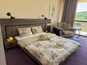 a bedroom with a bed and a chair and a window at Golden Lemon in Varna City