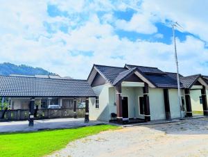 a house with a green lawn in front of it at Mimpi Hillview Homestay in Kuala Terengganu