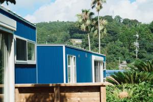 ein blaues kleines Haus mit einem Berg im Hintergrund in der Unterkunft 1NLDK hyuga in Hyuga
