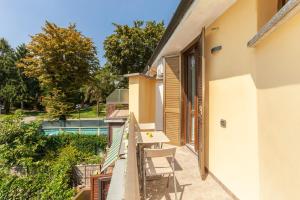 Un balcón de una casa con una mesa y sillas. en Bright Villa with Balcony and Jacuzzi, Milan Area, en Cesate