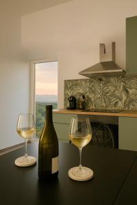 a bottle of wine and two glasses on a table at Suite Sole & Boutique Rooms in Norma