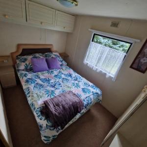 a small bedroom with a bed and a window at Domek nad Brennicą in Brenna
