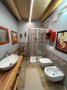 un bagno con due lavandini e una doccia di Casa Renzo ad Arco Altre 8 foto