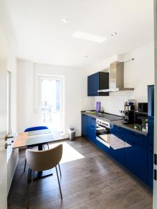 a kitchen with blue cabinets and a wooden table at npartment - Leverkusen City in Leverkusen
