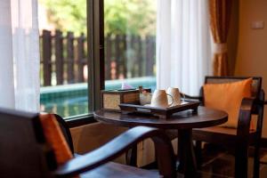 a table with vases on a tray in front of a window at CM Night Bazaar Boutique Hotel - โรงแรม ซี เอ็ม ไนท์บาซาร์ บูทีค in Chiang Mai