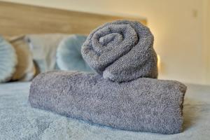 a pile of towels sitting on top of a bed at Hollins House, Free Street Parking, Long or Short Stays - by NMB Property in Hollinwood