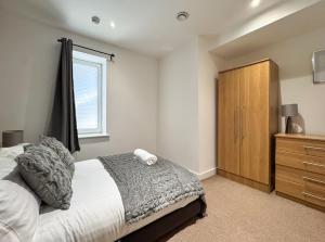 a bedroom with a bed and a wooden cabinet at Stylish Loft Apartment Weekend Holiday Stay in Central Station