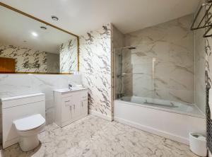 a bathroom with a tub and a toilet and a shower at Stylish Loft Apartment Weekend Holiday Stay in Central Station