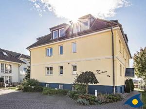 a large yellow house with a black roof at Inselhaus Whg 03 in Stubbenfelde