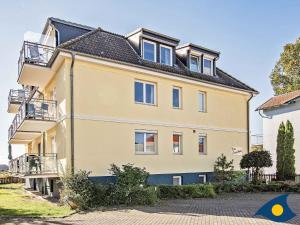 a large yellow house with a black roof at Inselhaus Whg 03 in Stubbenfelde