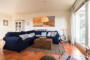 a living room with a blue couch and a table at Inselhaus Whg 03 in Stubbenfelde