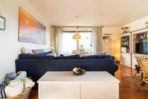 a living room with a blue couch and a table at Inselhaus Whg 03 in Stubbenfelde +8 photos