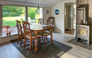 una sala da pranzo con tavolo e camino di Three Bedroom Gorgeous Home In Sæby a Sæby
