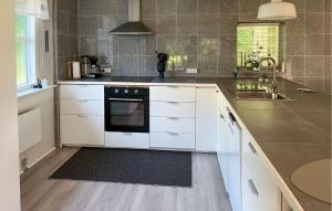 una cucina con mobili bianchi e un lavandino di Three Bedroom Gorgeous Home In Sæby a Sæby