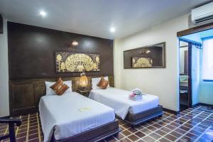 a hotel room with two beds in a room at CM Night Bazaar Boutique Hotel - โรงแรม ซี เอ็ม ไนท์บาซาร์ บูทีค in Chiang Mai +28 photos