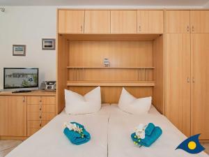 a bedroom with a large white bed with two pillows at Villa Margot Whg 30 in Bansin