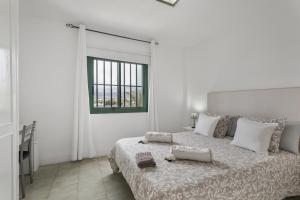 a white bedroom with a bed with two towels on it at Costa Serena in Arona +18 photos