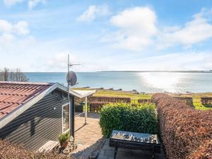 une maison avec un banc et une vue sur l'eau dans l'établissement Seaside Gem in Juelsminde - B B, à Sønderby
