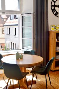 una sala da pranzo con tavolo, sedie e una finestra di Boutique Apartment LIMONIA - Historic Heart of Ulm a Ulma