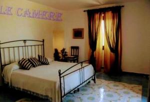 a bedroom with a bed and curtains and a window at Villa Regale B e B Country House in Piano di Santa Laura
