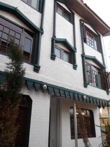 a white building with windows and a door at Al Amin Homestay in Srinagar