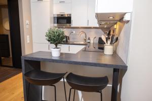 a kitchen with a counter with two stools at Moderne leilighet sentralt på Tromsøya in Tromsø +22 photos