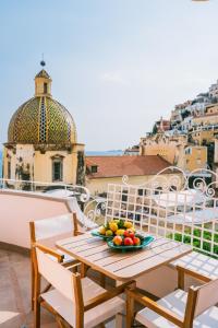 a table with a bowl of fruit on a balcony at Dimora Donna Teresa in Positano +50 photos