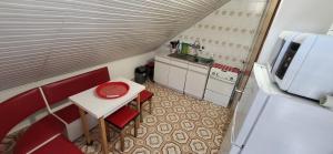a small kitchen with a table and a refrigerator at Z21 Apartman in Balatonföldvár