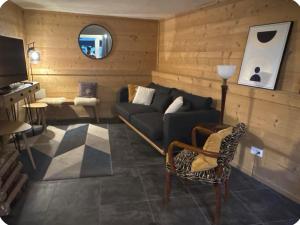 a living room with a couch and a chair at Maison Familiale Style Chalet - Centre village in Formiguères