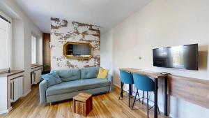 a living room with a couch and a table with blue chairs at The Hideout in Žilina