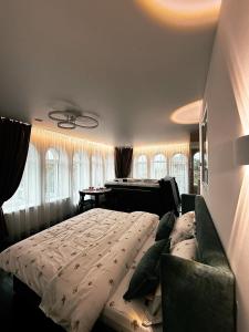 a bedroom with a bed and a couch and windows at APETIKO APARTMENTs in Kyiv