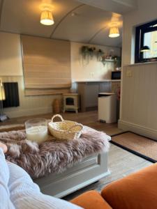 a living room with a couch and a table with a candle at The Shepherds Chalet in Garstang