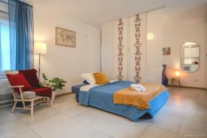 a bedroom with a bed and a chair at Case Ospitali - Casa Amiga, monolocale con stile e calore a Cernusco x3 in Cernusco sul Naviglio