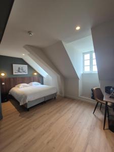 a bedroom with a bed in an attic at Hôtel l'Hermine - Vannes Port de plaisance in Vannes