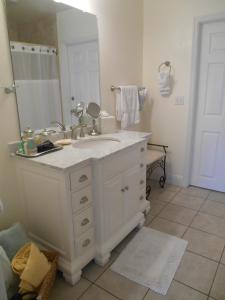 a bathroom with a sink and a large mirror at Windemere Inn by the Sea in Melbourne