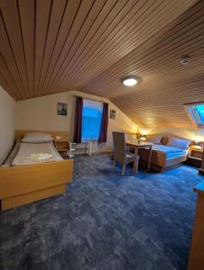 a hotel room with two beds and a table at Hotel & Restaurant Rösselsquelle in Ludwigswinkel