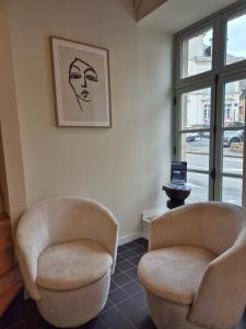 two chairs sitting in a room with a window at Hôtel l'Hermine - Vannes Port de plaisance in Vannes