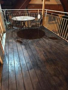 une table et des chaises assises sur une terrasse en bois dans l'établissement Bat Galim Sea & Rambam-Beachfront & Medical Stay, à Haïfa