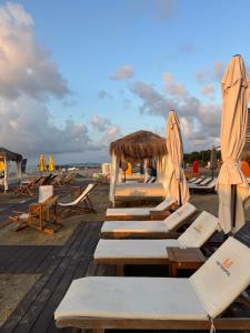 a group of lounge chairs and umbrellas on a beach at Orbi City Luxury Suites in Batumi