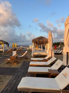 a group of lounge chairs and umbrellas on a beach at Alliance Palace In Batumi in Batumi